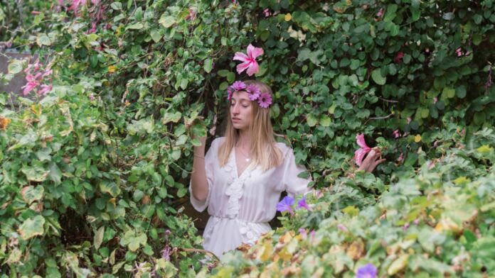 nő virágokkal a zöldben